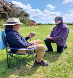 two men looking at egg-shaped stone