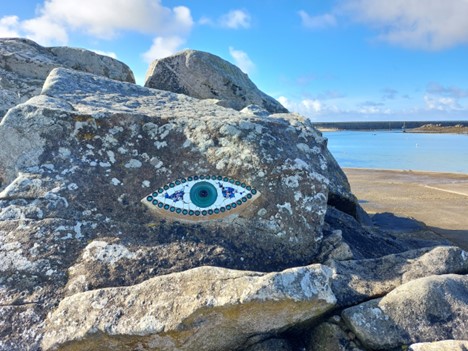 large rock formation with bright blue eye painted on